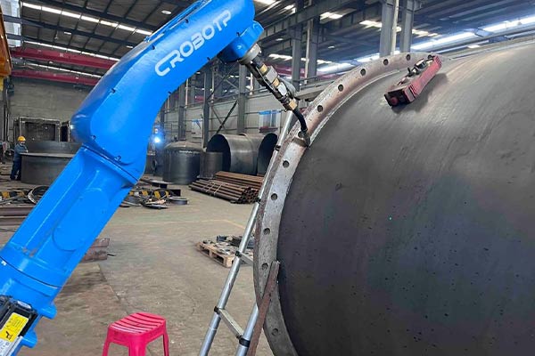 Robot performing automated welding on a large amusement ride component, demonstrating advanced robotic welding technology in amusement ride production.