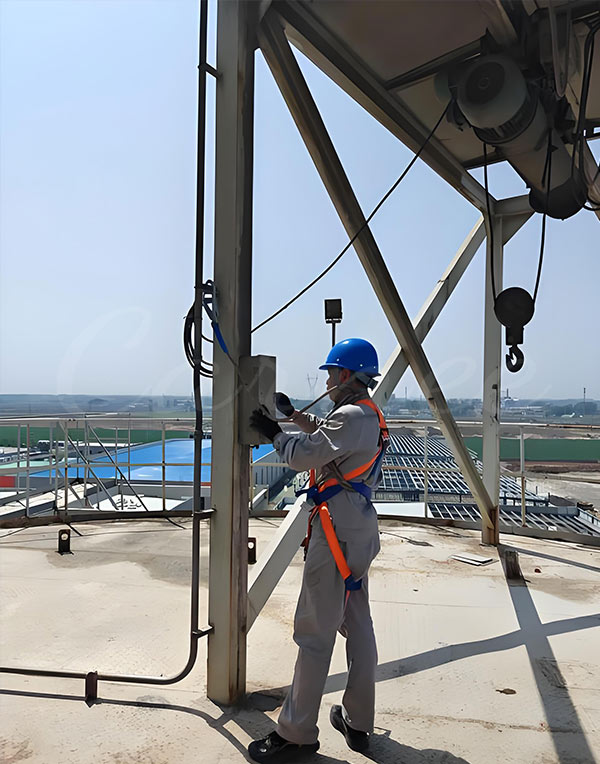 Technician performing maintenance on a drop tower ride, ensuring safety and reliability of the amusement park ride.