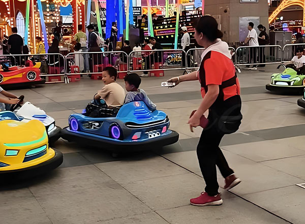 Adult supervising children riding bumper cars to ensure safety