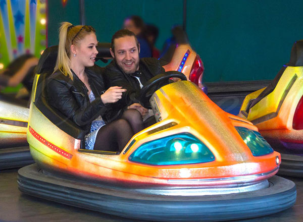 Adults enjoying bumper cars in a family entertainment setting