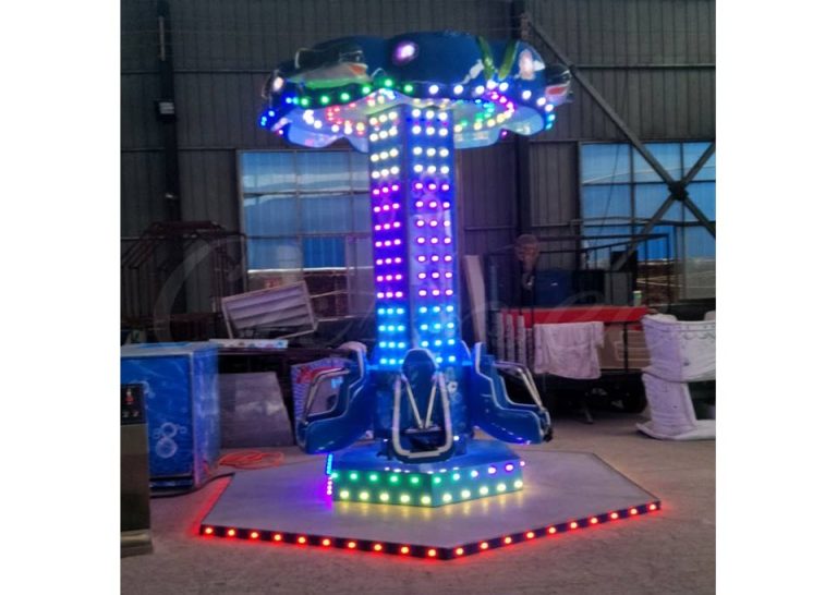Torre de saltos giratoria para niños instalada en un centro de ocio familiar con luces LED