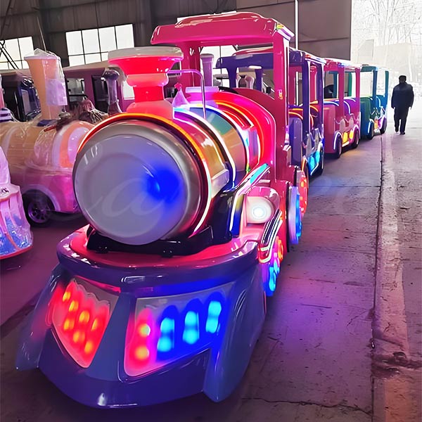 Um trem sem trilhos para crianças iluminado por neon, geralmente chamado de Land Train no Reino Unido, recém-fabricado e pronto para exportação na fábrica da Carnee Rides.