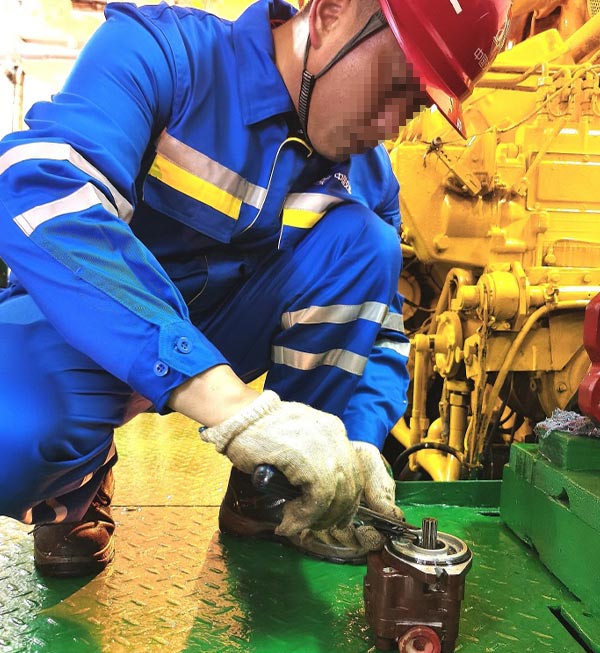Teknisi pemeliharaan wahana hiburan profesional sedang memperbaiki komponen drivetrain mekanis untuk mengurangi waktu henti wahana dan mengelola biaya pemeliharaan jangka panjang.