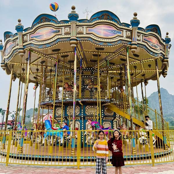 Vista completa de una atracción de carrusel de 48 plazas y dos pisos en venta, personalizada con colores vibrantes para una atracción turística al aire libre en Vietnam.