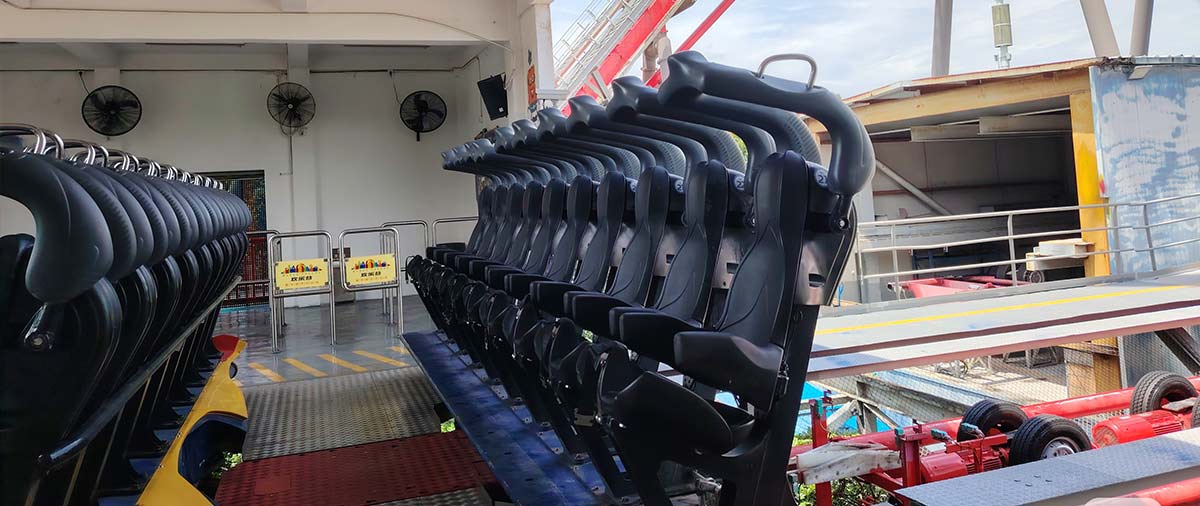 Pengaman Over-The-Shoulder Restraints (OTSR) pada wahana pendulum yang sedang menunggu pemeriksaan keselamatan harian dan verifikasi kunci hidrolik untuk memastikan keamanan taman hiburan.