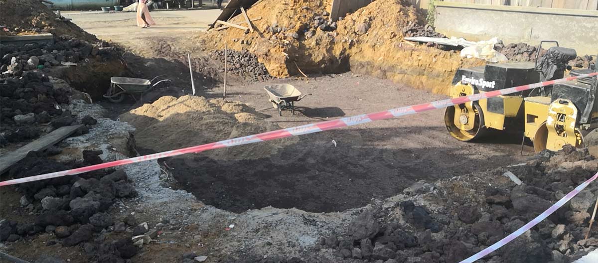 Excavación de una fosa de cimentación profunda para una torre de caída de 30 m en la construcción de un parque de atracciones en Camerún, preparando el suelo tropical blando para la estabilización estructural.