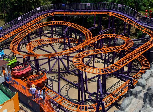 A compacta montanha-russa giratória familiar roxa e laranja é uma excelente opção para reduzir o custo de construção de uma montanha-russa pequena e, ao mesmo tempo, maximizar o rendimento do parque.