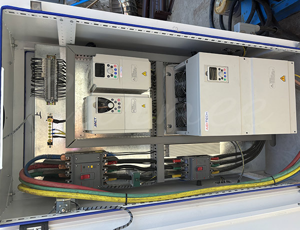 En el interior del armario de control eléctrico PLC principal de una atracción de torre de caída libre, se muestran inversores y relés de seguridad de alta gama que gestionan las comunicaciones y la automatización de los sensores de la zona de caída de la atracción.