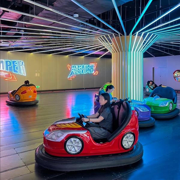 Para tamu menikmati mobil dodgem warna-warni di pusat hiburan dalam ruangan yang diterangi lampu neon, menghasilkan ROI maksimum melalui perawatan wahana harian yang proaktif.