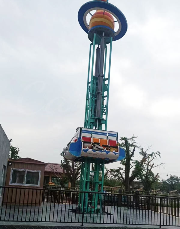 Une tour de chute personnalisée avec un thème planétaire unique et une nacelle sécurisée, installée dans un parc d'attractions familial.