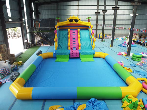 Vista frontal de tobogán acuático hinchable comercial con piscina, tema sol con carriles dobles y borde de piscina amarillo