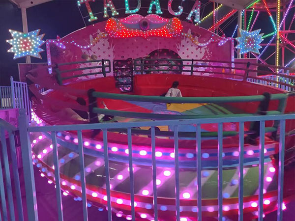 Manège Disco Tagada avec lumières LED colorées, plate-forme rembourrée, mains courantes et barrière de sécurité pour les opérations nocturnes