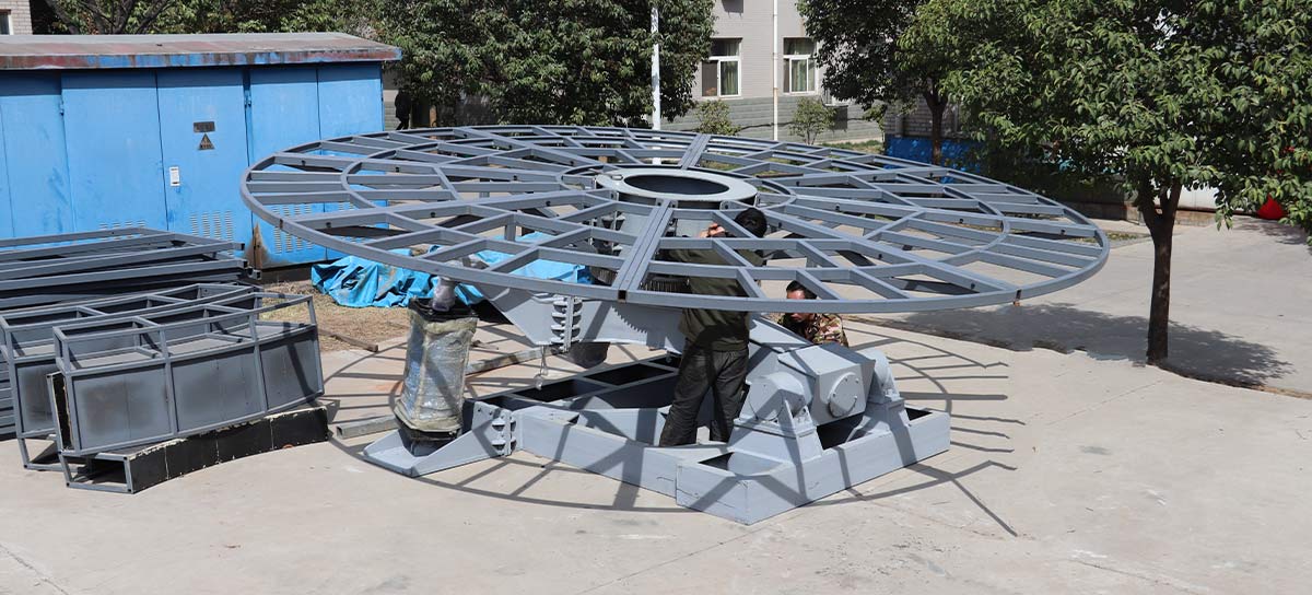 Assemblage du cadre du plateau tournant de la discothèque Tagada montrant la structure de la plate-forme en acier, le support central et les travaux d'installation mécanique