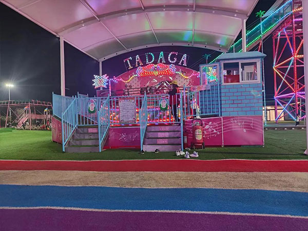 Manège Tagada installé de nuit avec des lumières LED, une cabine de contrôle, des escaliers et une clôture de sécurité pour l'exploitation d'un parc d'attractions
