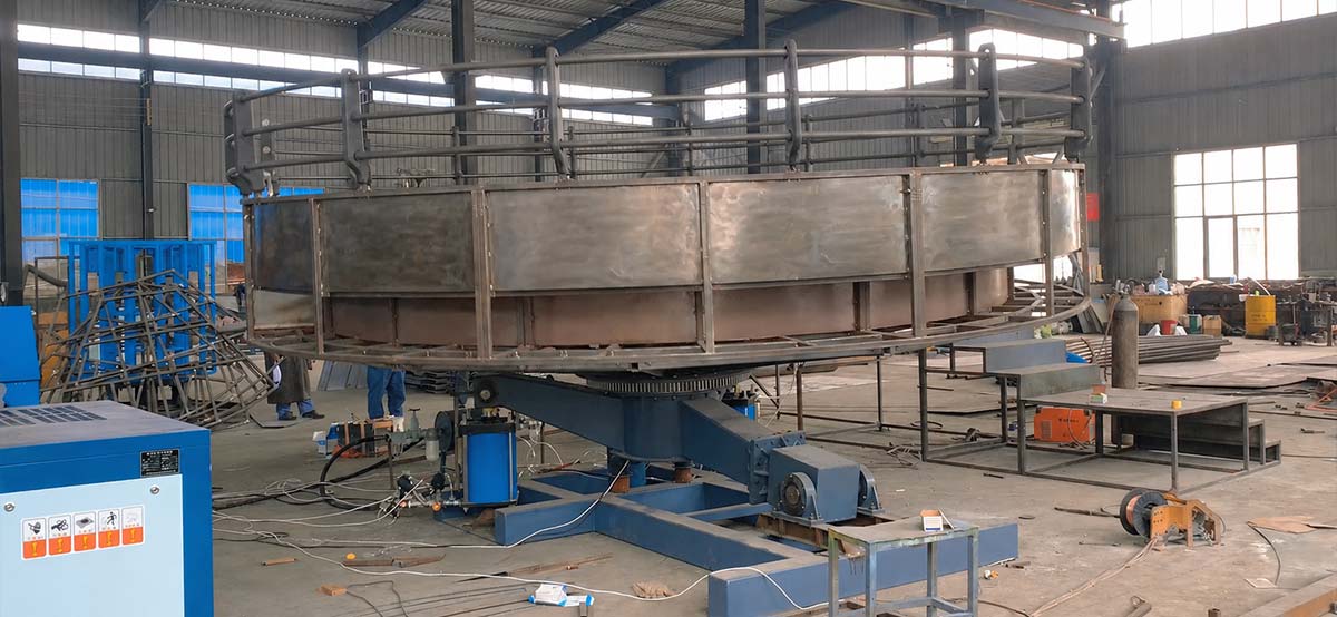 Système d'entraînement hydraulique et structure de base sous un manège « Disco Tagada » lors du montage en usine