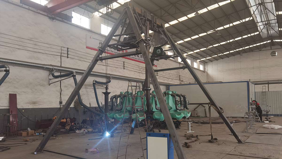 Ingeniería y fabricación de precisión de una atracción de tipo péndulo que destaca por la soldadura de su estructura en forma de A de acero de alta resistencia, el montaje del eje de transmisión central y un estricto control de calidad mediante ensayos no destructivos (END).